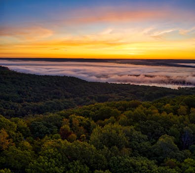 A stunning aerial view of the sunrise over the foggy forests of Devils Corner, Wisconsin.