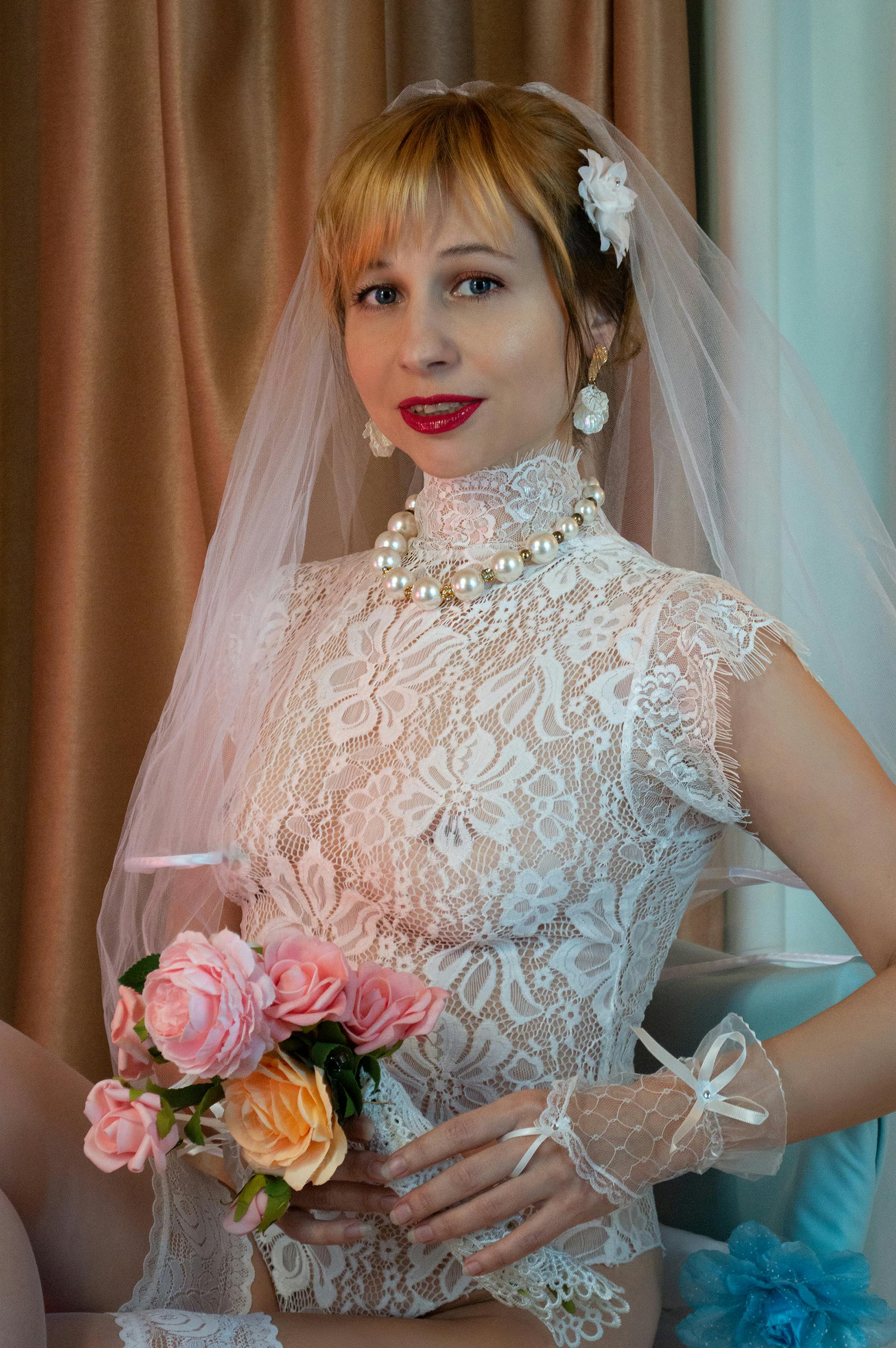 woman in white floral lace top holding bouquet of flowers