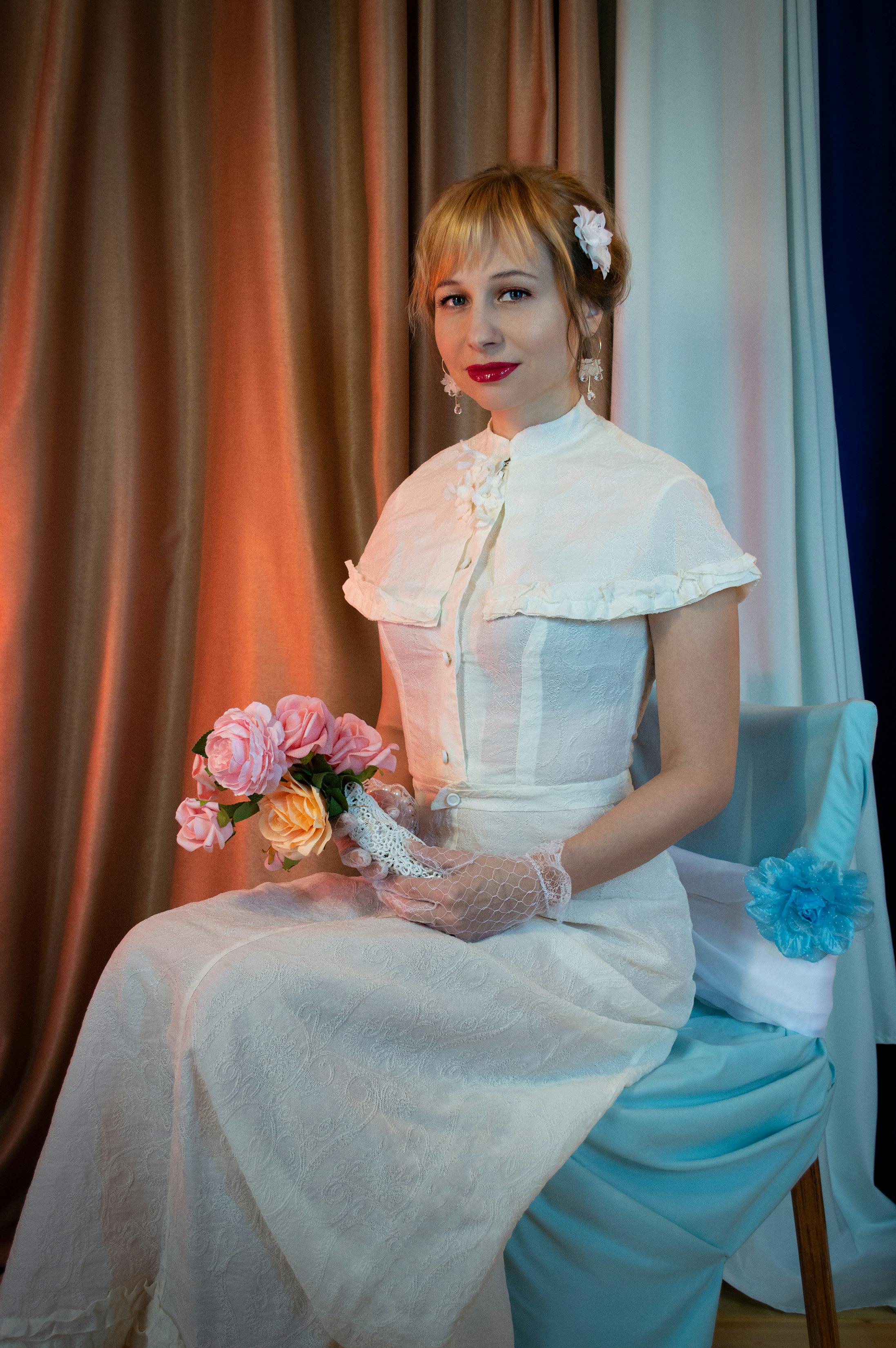 girl in white dress holding bouquet of flowers