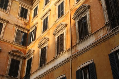 Free Warm-toned facade of historic European architecture with classic shuttered windows. Stock Photo