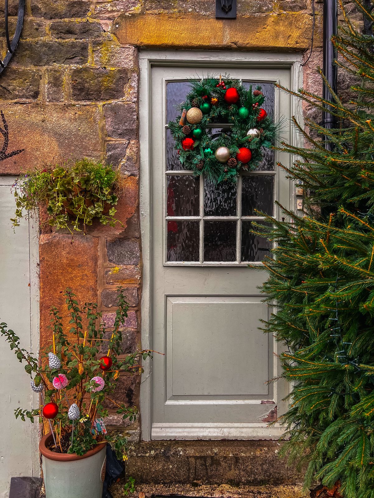 A restrained Christmas front entrance with a wreath and potted greenery, representative of The Refresh styling scale.