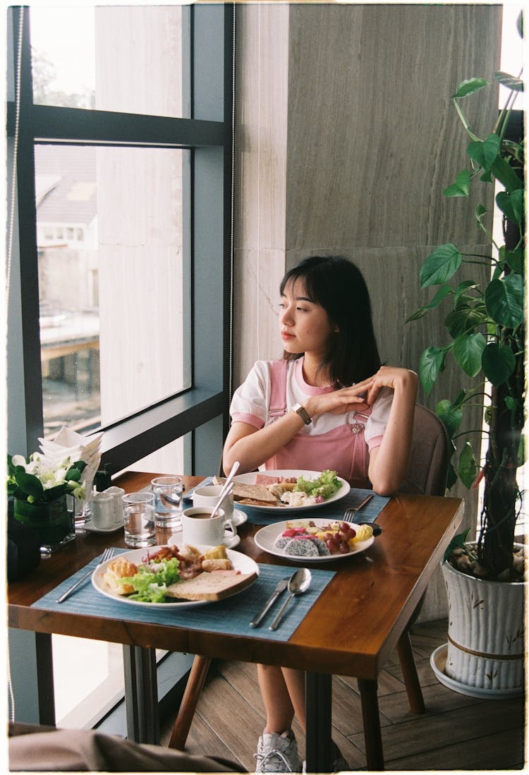 Woman Eating Breakfast In Cafe