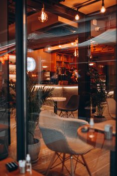 Inviting empty coffee shop with warm lighting, modern decor, and cozy ambiance for relaxation.