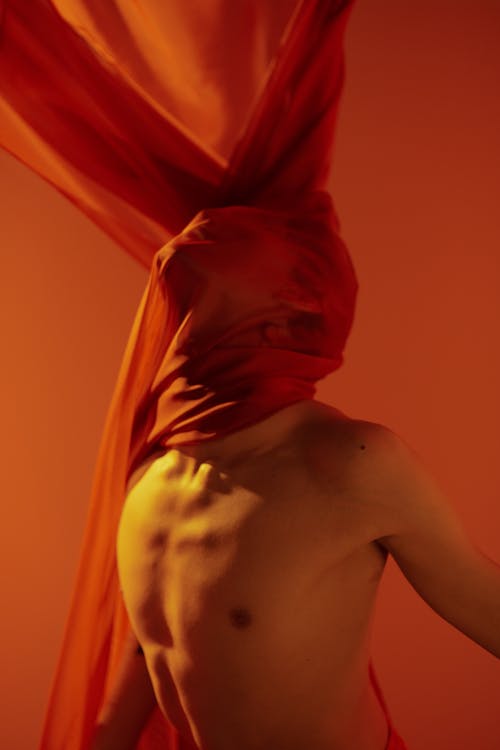 Shirtless Man with Head Covered in Red Fabric
