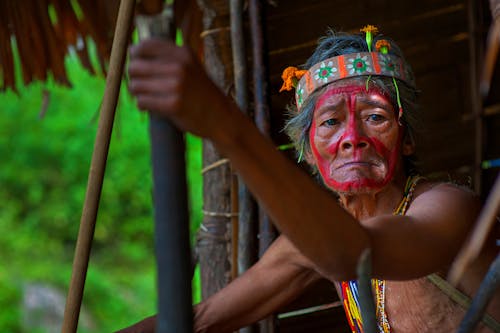 Selective Focus Photography of Man Holding Stick Wearing Headband