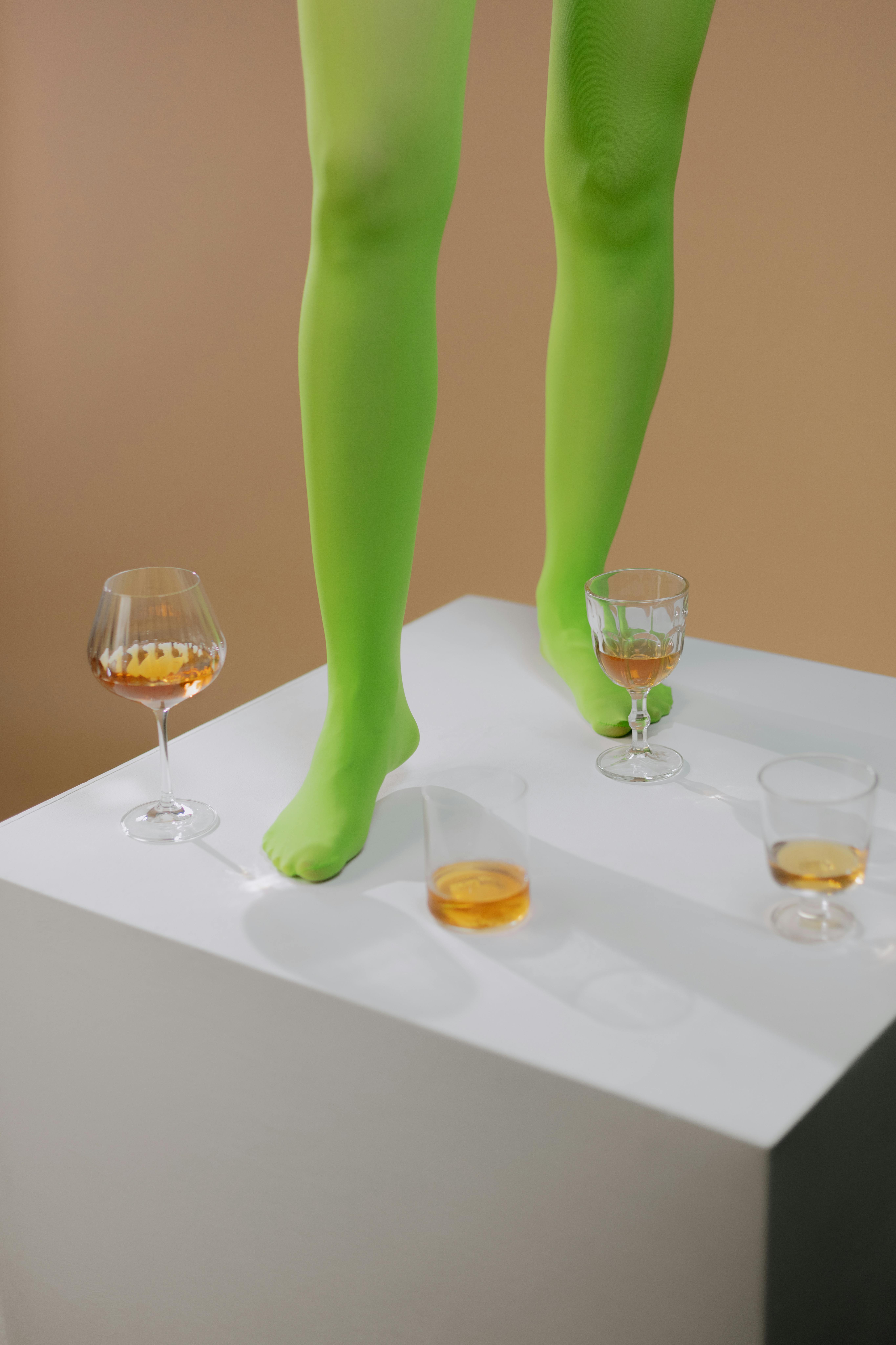 legs standing on white table with glasses