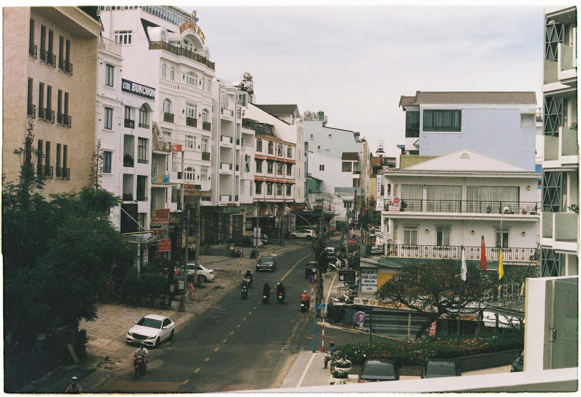 Urban street with residential buildings and mixed local transportation.