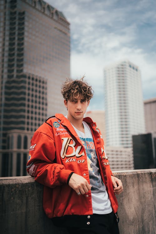 Man in Red Jacket Leaning on Wall