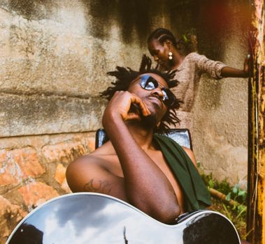 A thoughtful musician with a guitar in an outdoor urban atmosphere. Captivating moment.