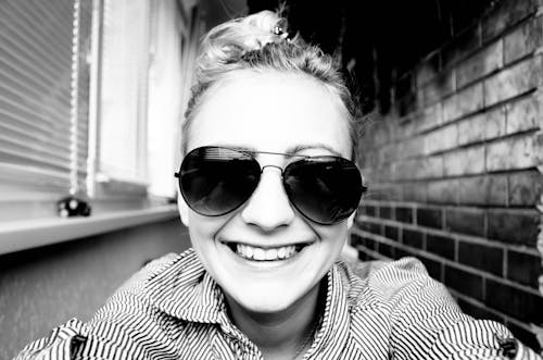 Free Grayscale Photo of a Smiling Woman Wearing Sunglasses Stock Photo