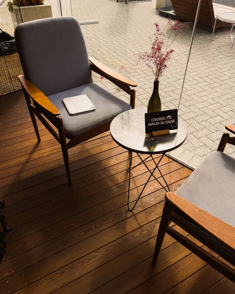 Vase With Flower On Table Near Armchair