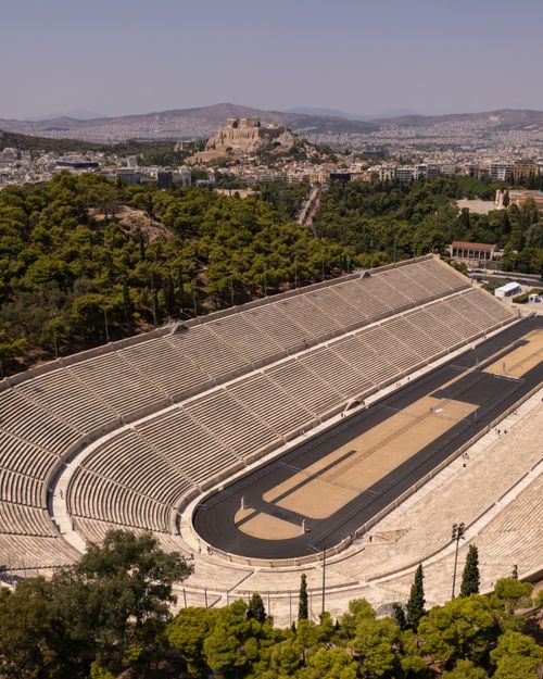 Free A stunning aerial view of the historic Panathenaic Stadium in Athens, Greece, with the Acropolis in the background. Stock Photo