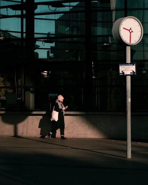 Woman Walking by a Modern Building