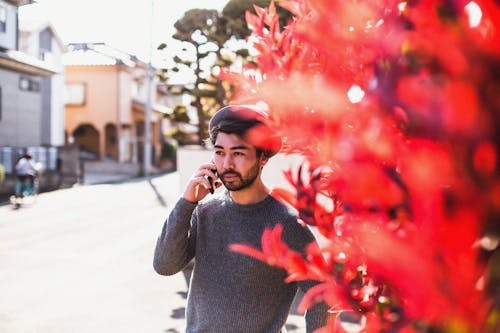 Free A Man in Gray Sweater Talking on the Phone Stock Photo