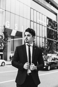 Elegant Asian man in suit on bustling Tokyo street in grayscale