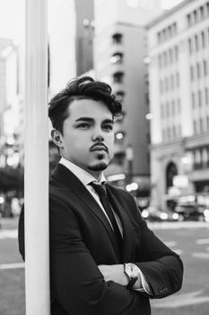 Sophisticated black and white portrait of a man in a suit, taken in the bustling streets of Tokyo.