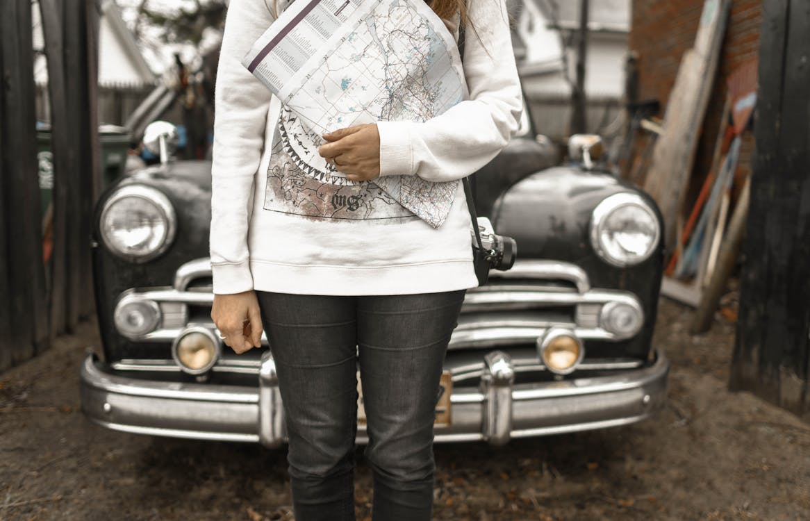 Free Person Holding Map With Car at the Back Stock Photo