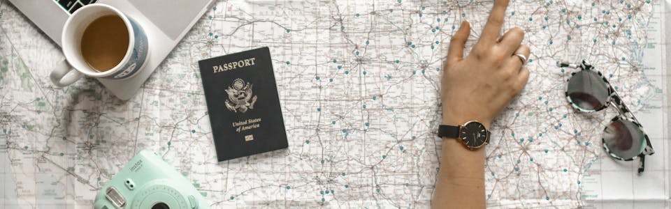 Person Pointing at Black and Gray Film Camera Near Macbook Pro