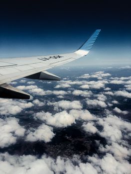 A stunning aerial view showing fluffy clouds from an airplane wing high above the earth.