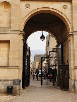 Gothic archway leading to historic buildings in Oxford, England. A popular tourist destination.