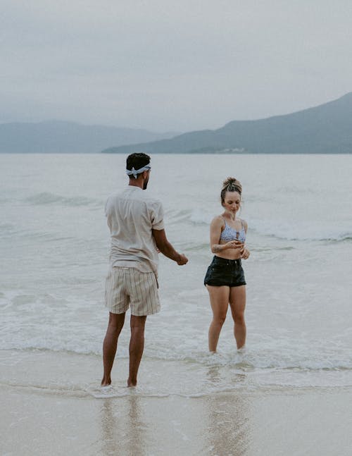 Man and Woman Standing on the Beach