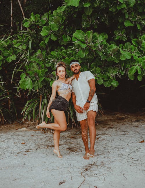 A Couple Standing on the Sand Barefooted