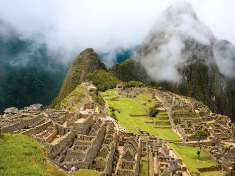 Explore the breathtaking ancient ruins of Machu Picchu in Peru with misty mountains as a backdrop.