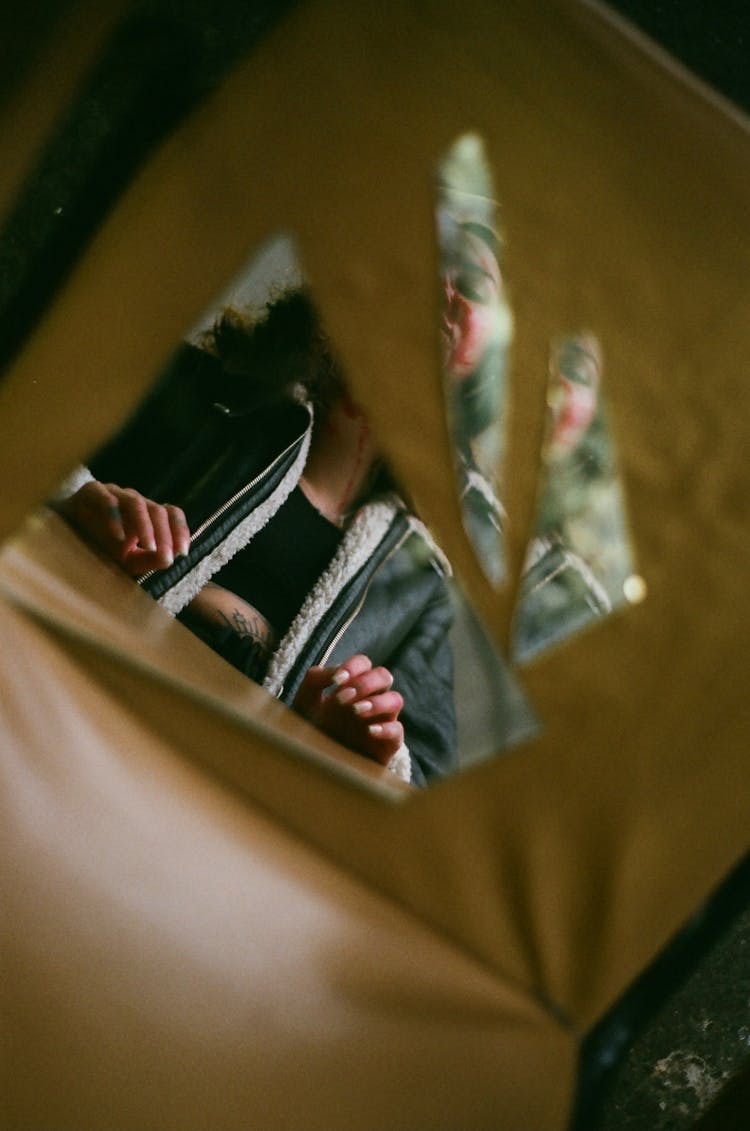 Reflection Of A Woman In Pieces Of A Broken Mirror