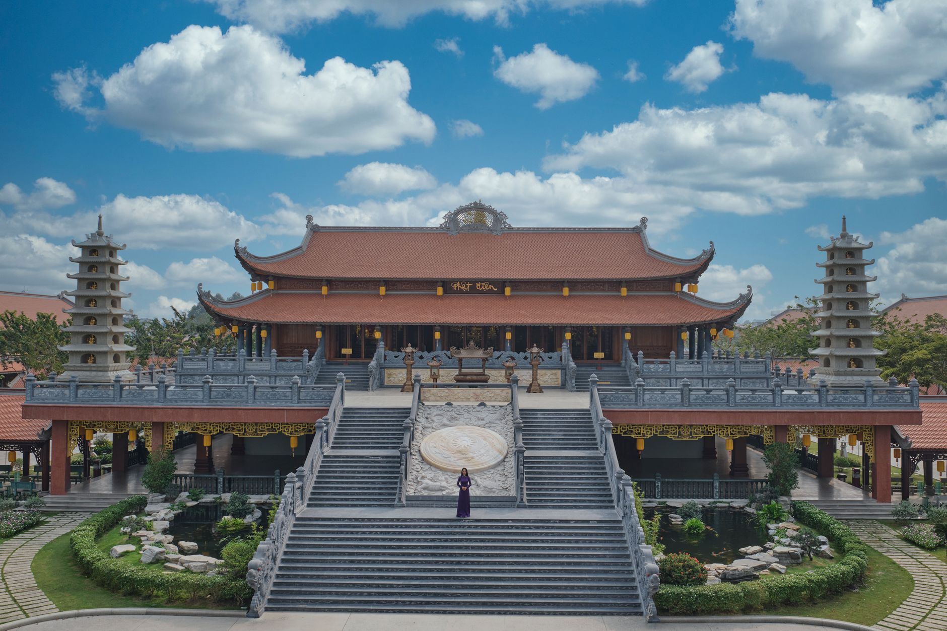 Explore the serene architecture of a Vietnamese Buddhist temple from an aerial perspective with clear blue skies.