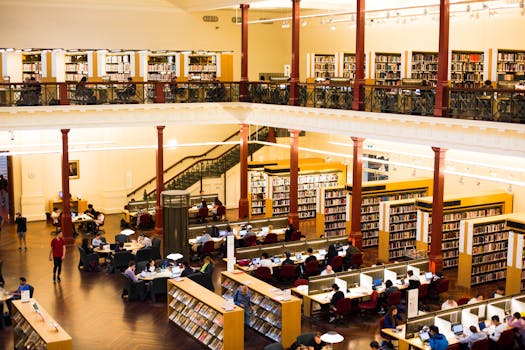 A busy library scene captures visitors studying and reading in a historic Melbourne building.