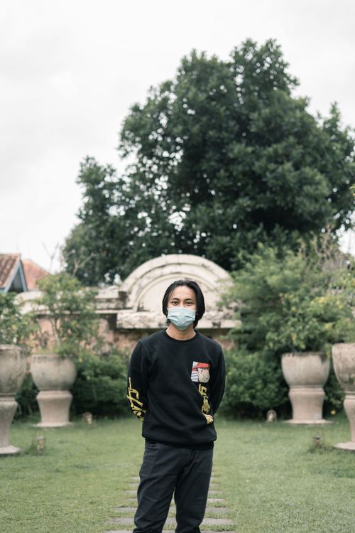 Free Asian man in a garden with face mask, illustrating pandemic new normal lifestyle. Stock Photo