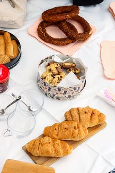 A variety of pastries and baked goods displayed on a rustic table setting, perfect for breakfast or brunch.