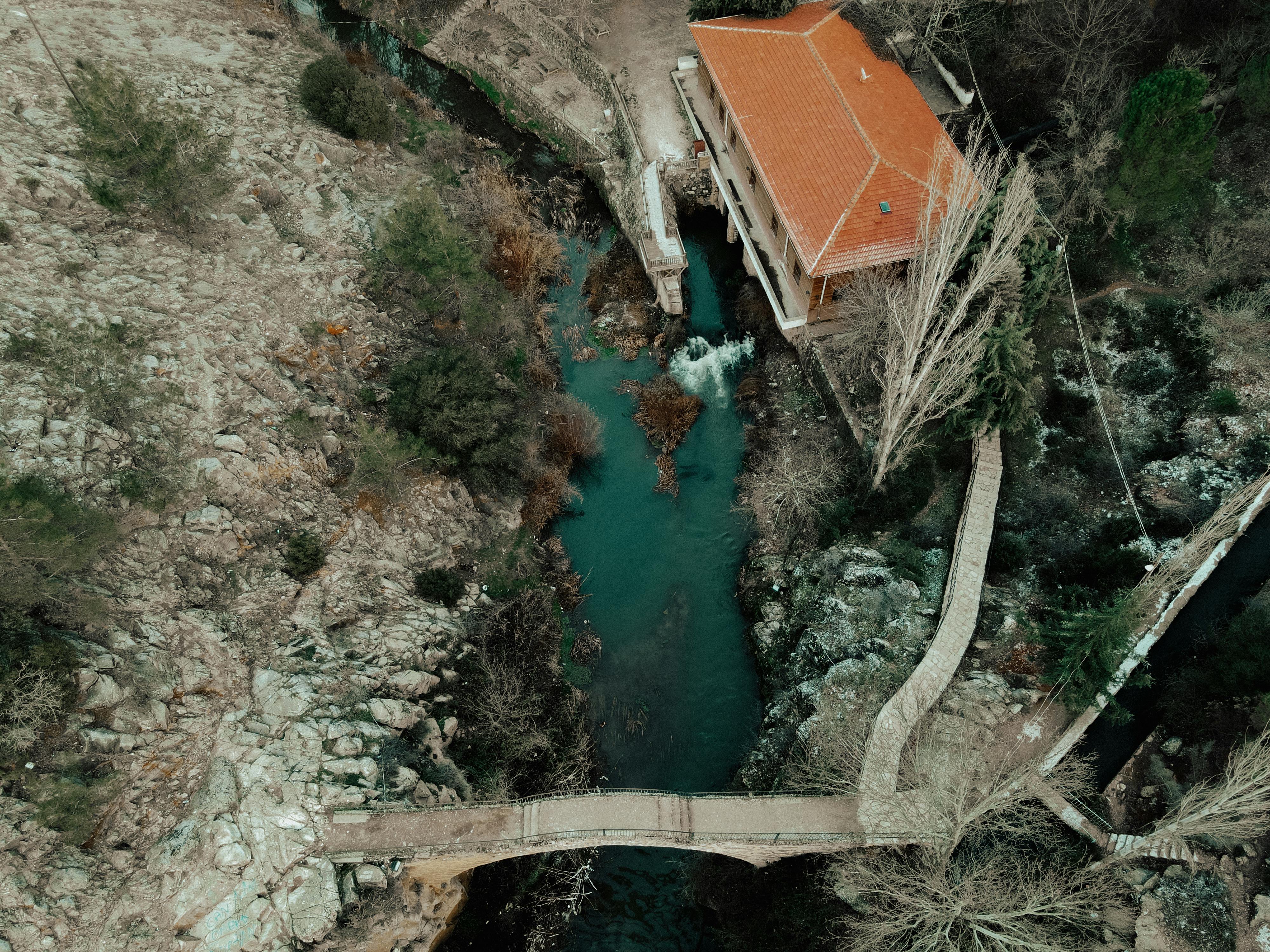 house with brick roof roof beside a creek