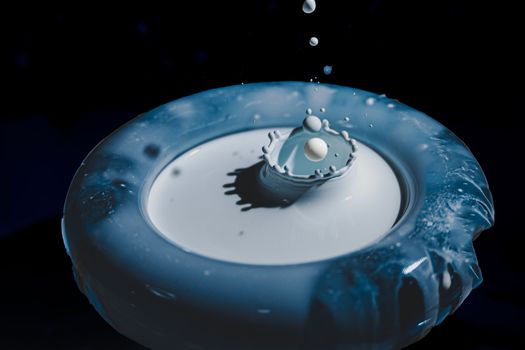 Artistic capture of milk splash with droplets in a dark setting, showcasing fluid dynamics.