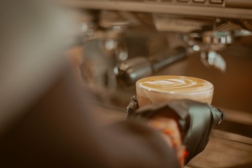 Free A barista holds a cappuccino with latte art in a Konya cafe, Turkey. Stock Photo