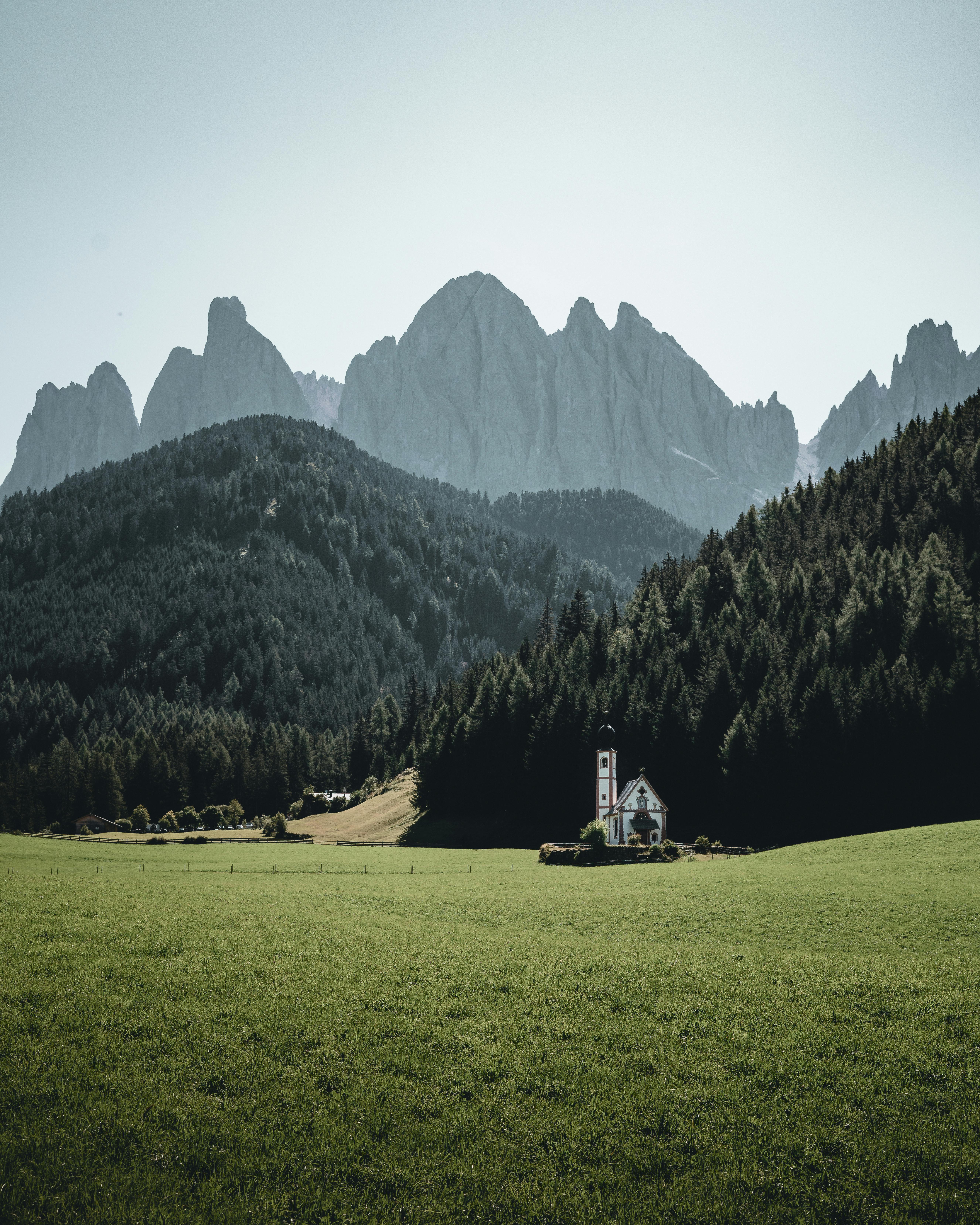 Picturesque view of a quaint church nestled against the majestic Dolomites in Italy.
