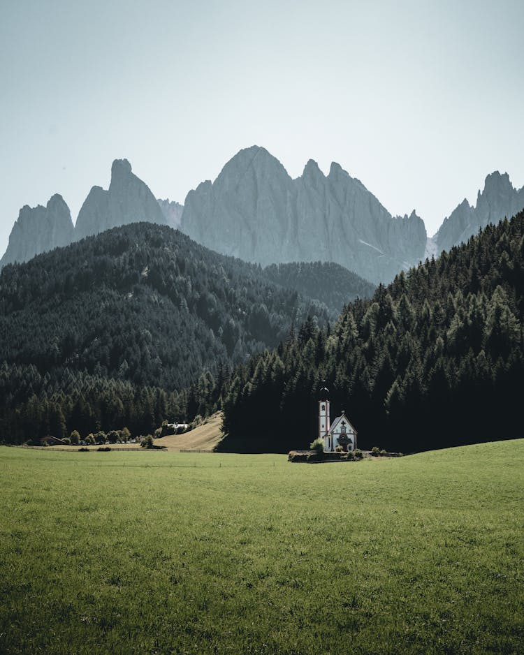 A Church On Green Grass Field Near Mountains