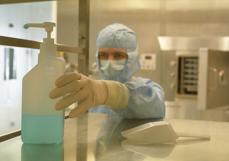 Pharmaceutical cleanroom worker with container