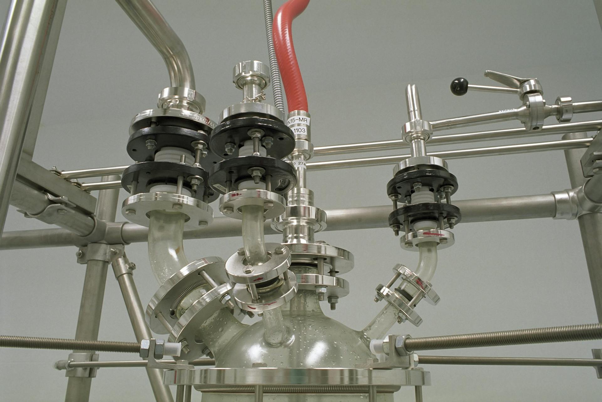 Close-up of stainless steel pipes and valves in a chemical industry setting.