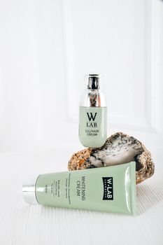 Elegant display of W Lab skincare products on a rock with white background.
