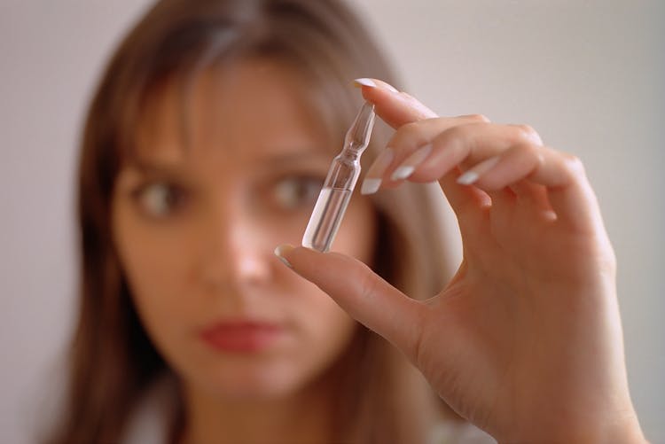 A Woman Holding An Ampoule