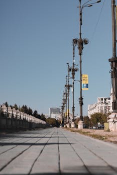 A serene urban street lined with vintage street lamps, captured under a clear sky, perfect for city atmospheres.
