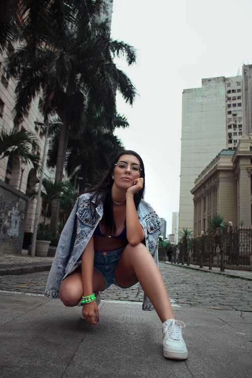 A Woman Crouching on Pavement