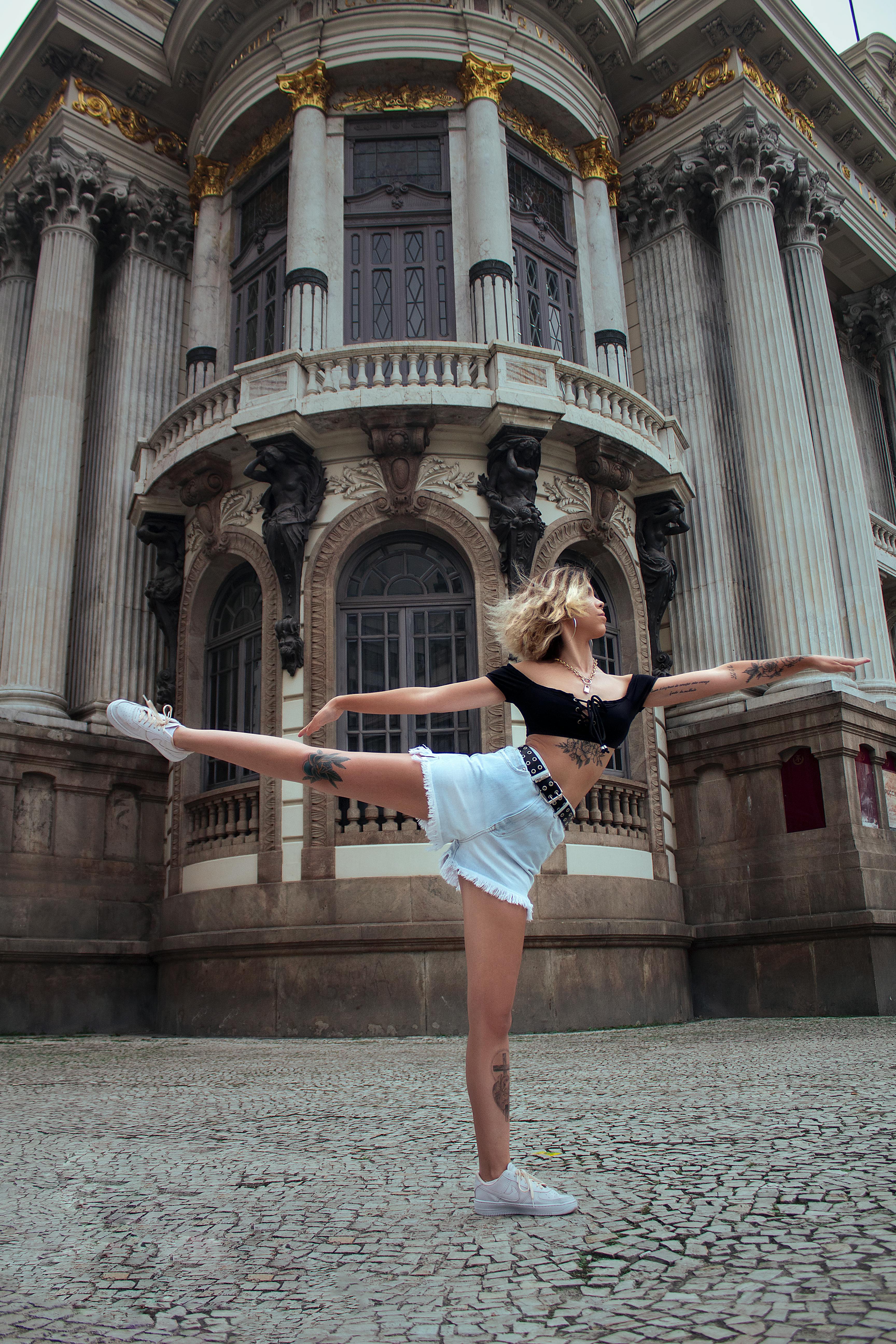 Photo of a Woman in a Black Crop Top Dancing Near a Building · Free