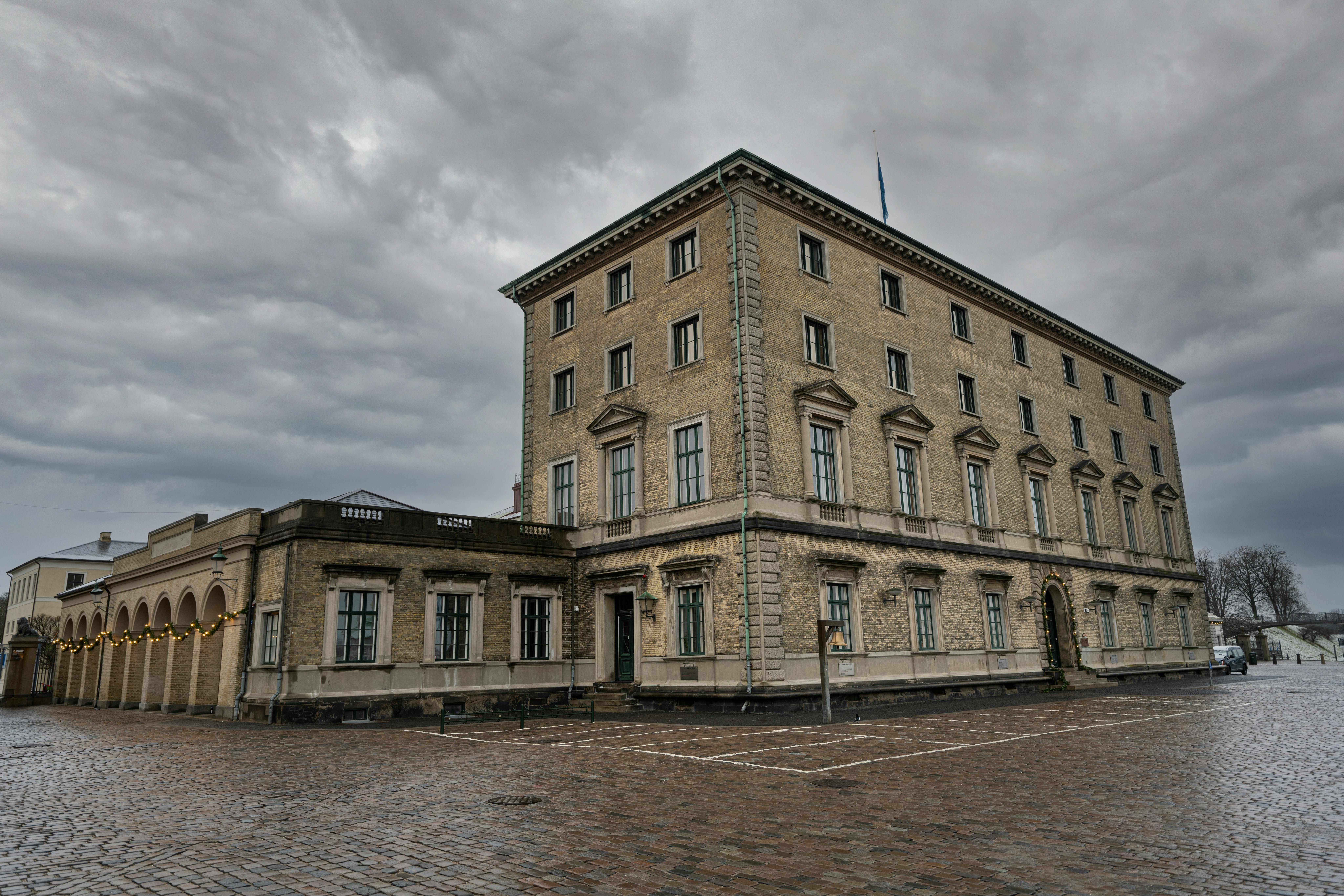 A dramatic view of a historic building in Copenhagen, Denmark under a cloudy sky. - Copenhague