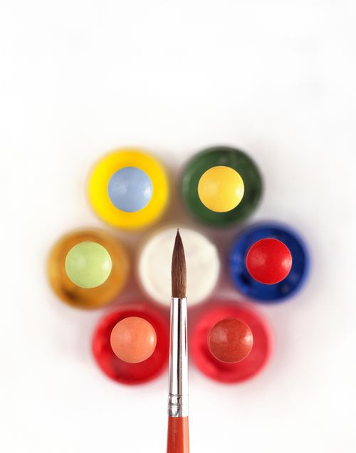 Free Close-up of a paintbrush with colorful paint bottles arranged in a creative pattern. Stock Photo