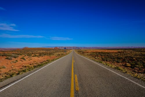 Free Straight Road Surrounded With Grass Stock Photo