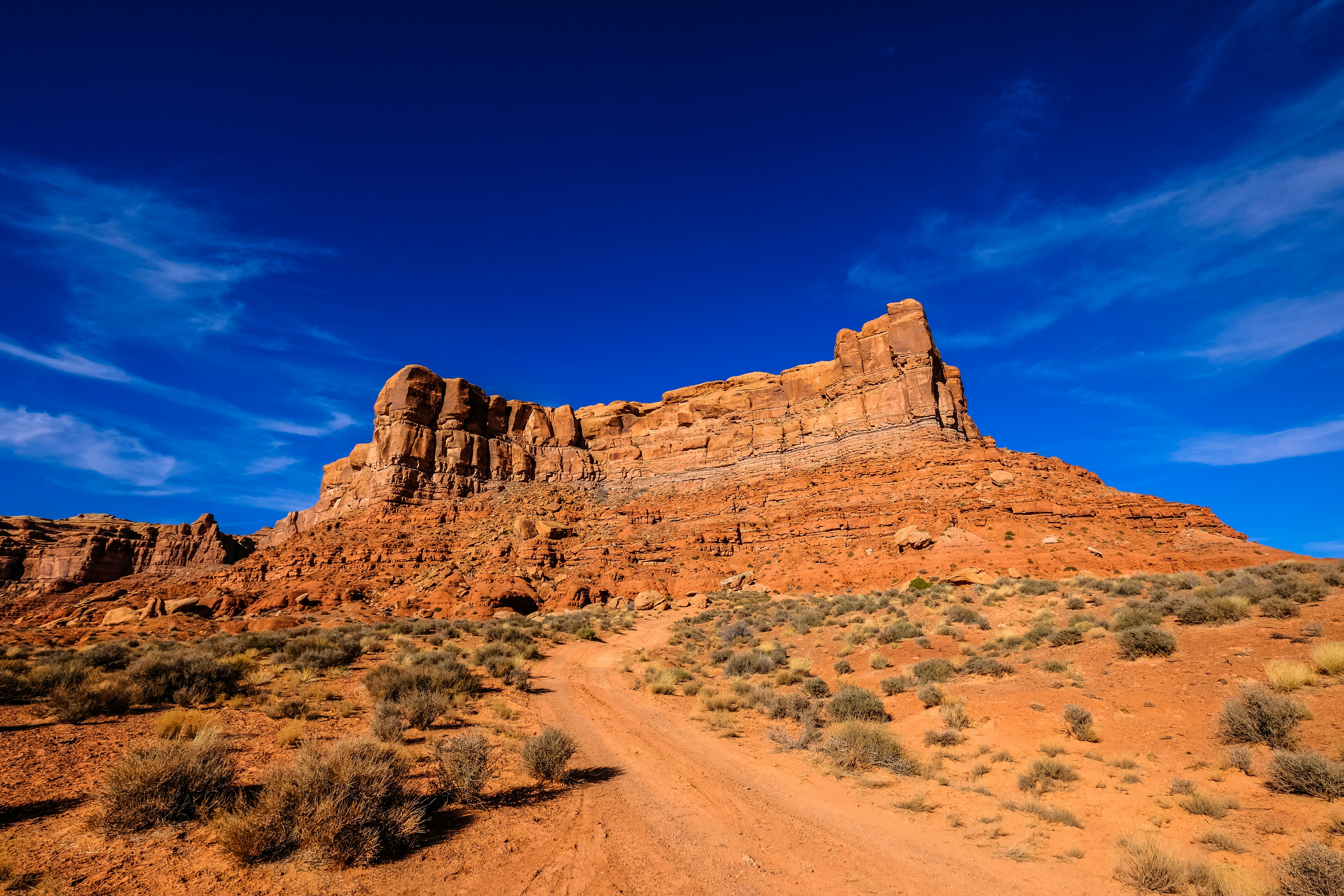 生动的沙漠场景，以引人注目的砂岩地层和充满活力的蓝天为特色