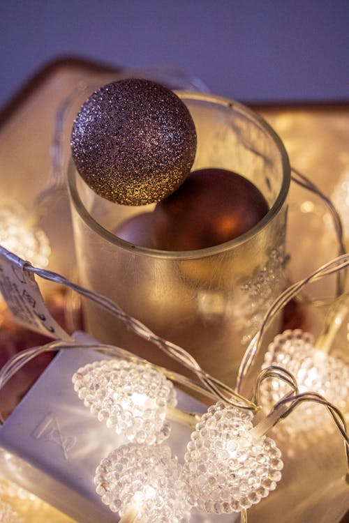 Illuminated String Lights Around a Glass with Christmas Balls 