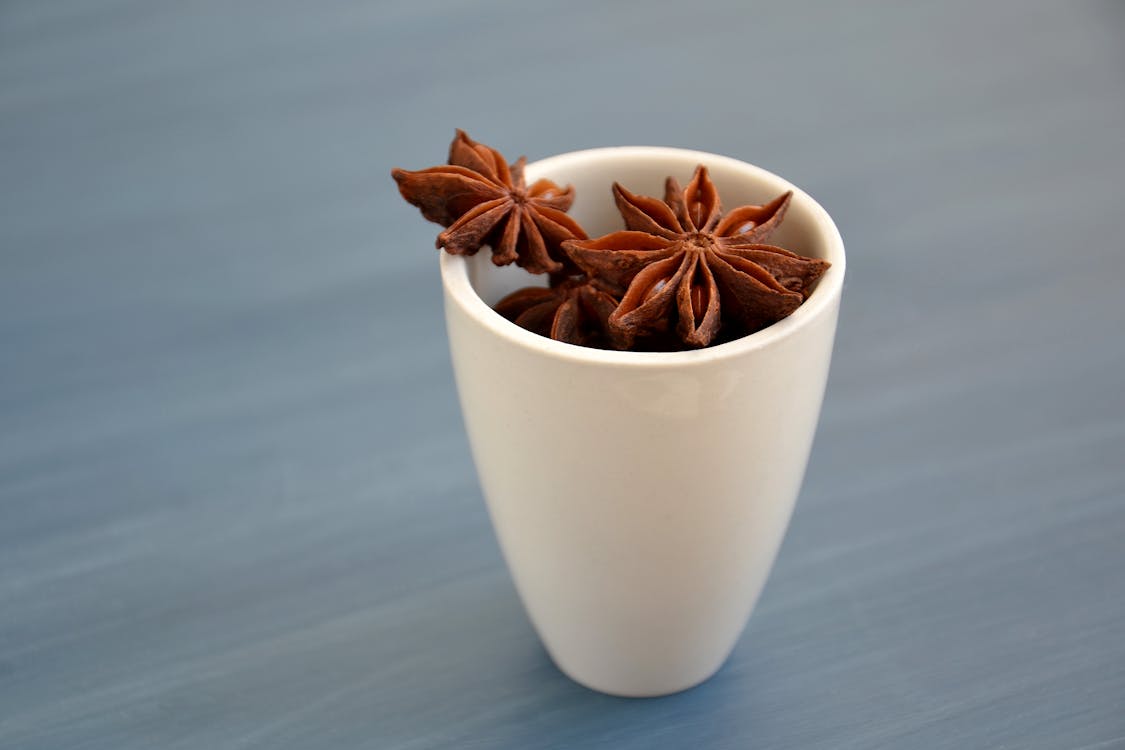 免费 棕色八角茴香在白色陶瓷杯上 素材图片